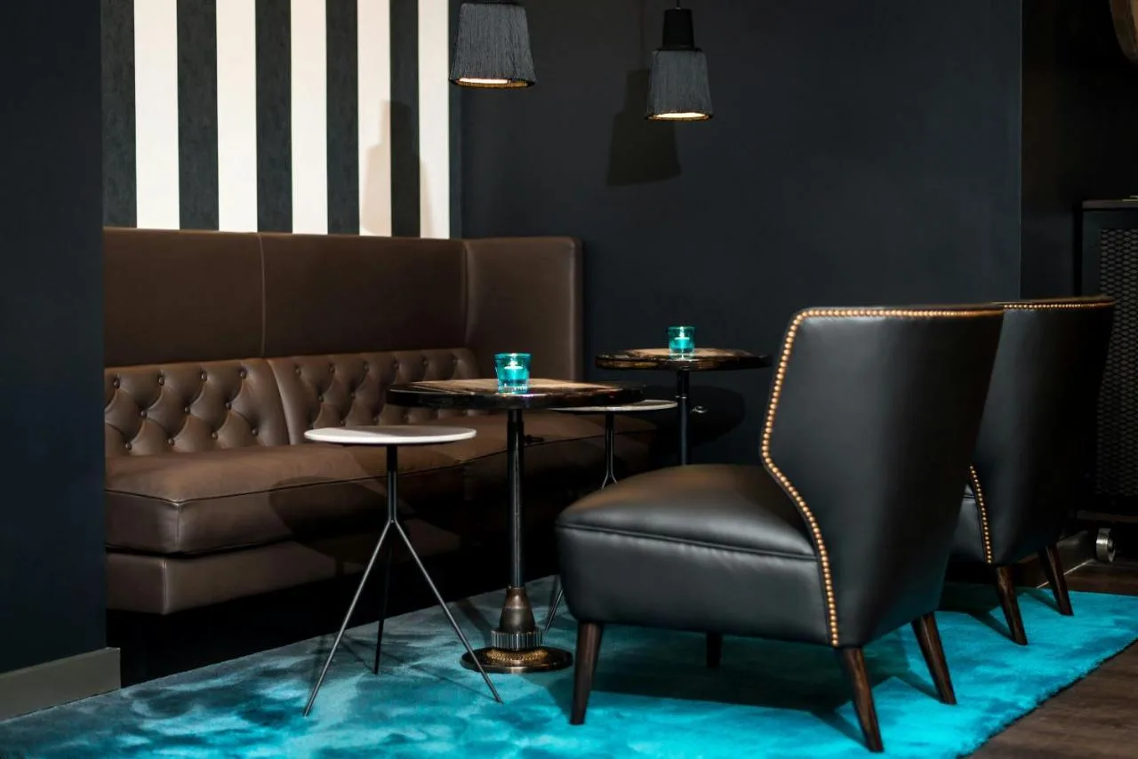 a bar with two tables and a couch at Motel One Newcastle in Newcastle upon Tyne